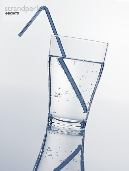 Ein Glas Mineralwasser mit Stroh