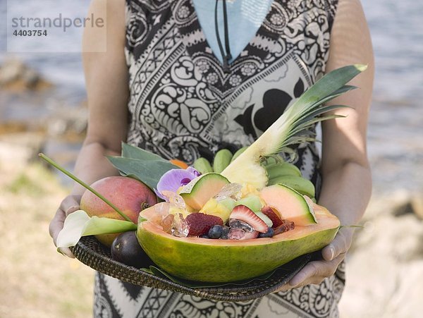 Frau hält Fach mit exotischen Früchten auf dem Seeweg