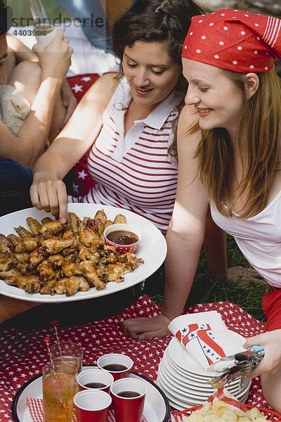 Junge Frauen in einem vierten Juli Picknick (USA)
