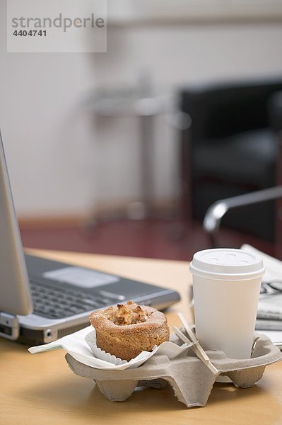 nebeneinander neben Seite an Seite Tasse Notebook Büro Kaffee Muffin