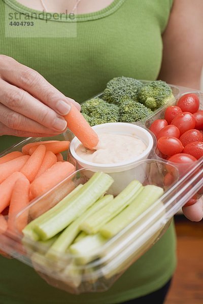 Frau hält Kunststoff Tray von Gemüse und dip