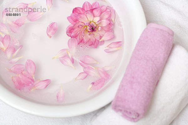 Pink Flower Petals in Schüssel mit Wasser  Handtücher daneben