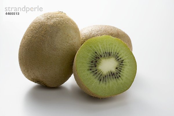 Hälfte ein Kiwi Obst an zwei ganze Kiwi-Früchte