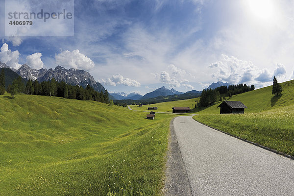 Deutschland  Bayern  Blick auf die Straße durch die ländliche Landschaft bei Karwendelgebirge