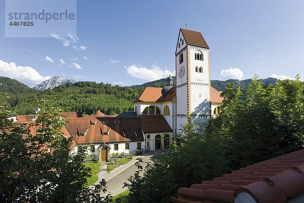 Deutschland  Bayern  Allgäu  Füssen  Blick auf die St.-Magnus-Kirche mit Bergen im Hintergrund