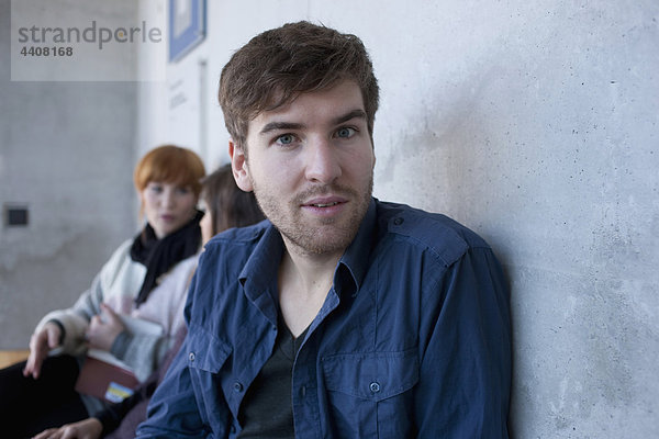 Junger Mann mit Studenten im Hintergrund