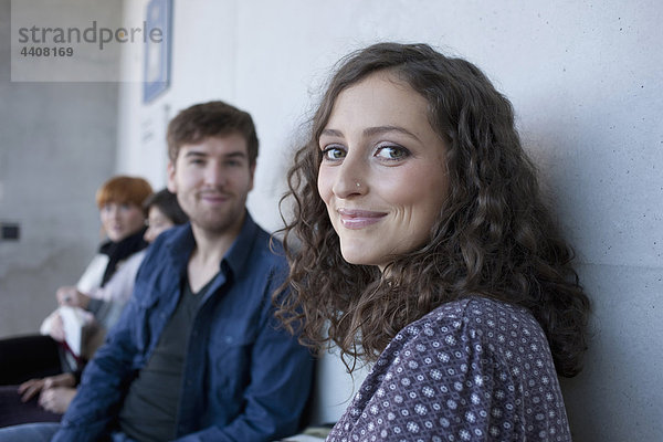 Mann und Frau lächeln  Studenten im Hintergrund