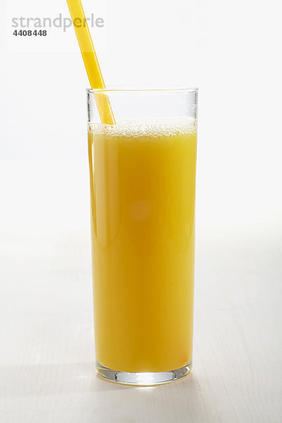 Glas Orangensaft mit Stroh auf weißem Grund