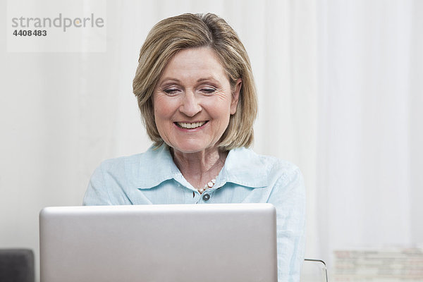 Frau mit Laptop  lächelnd