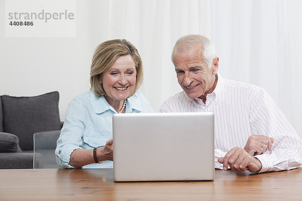 Senior Paar mit Laptop  lächelnd