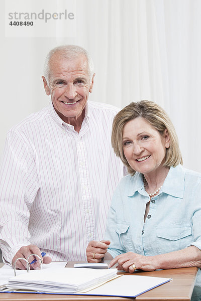 Seniorenpaar beim Papierkram  lächeln  Porträt