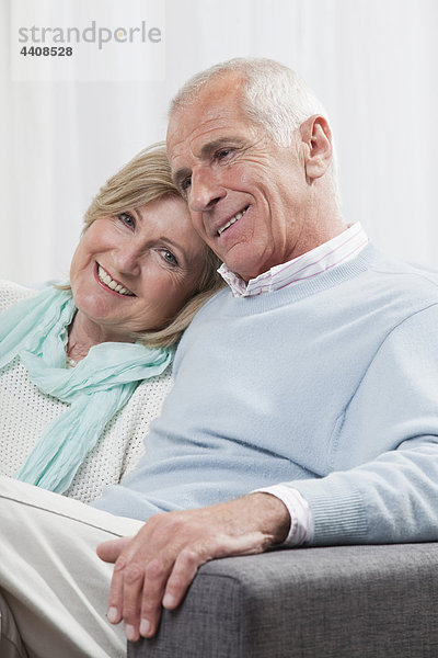 Seniorenpaar auf der Couch sitzend  lächelnd