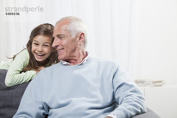 Enkelin (6-7) und Großvater lächelnd