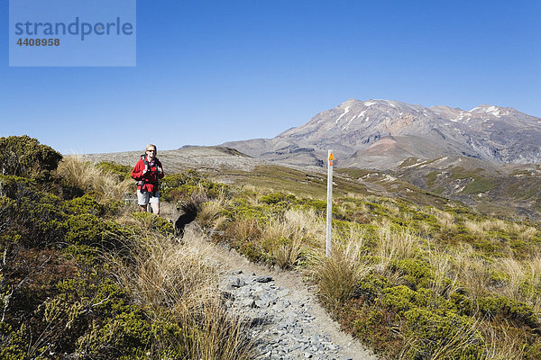 Neuseeland  Nordinsel  Frau beim Wandern im Tongariro-Nationalpark mit Berg Ruapehu im Hintergrund