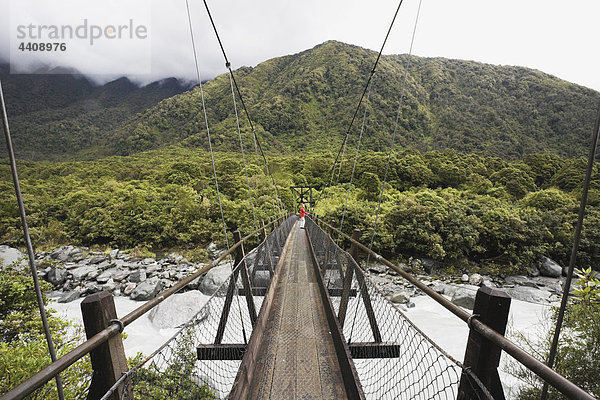 Neuseeland  Südinsel  Frau überquert Fuchsfluss durch Drehbrücke