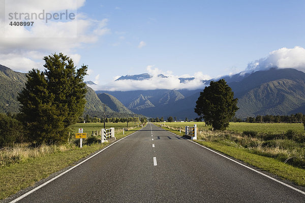 Neuseeland  Südinsel  Westküste  Blick auf leere Straße mit Bergen im Hintergrund