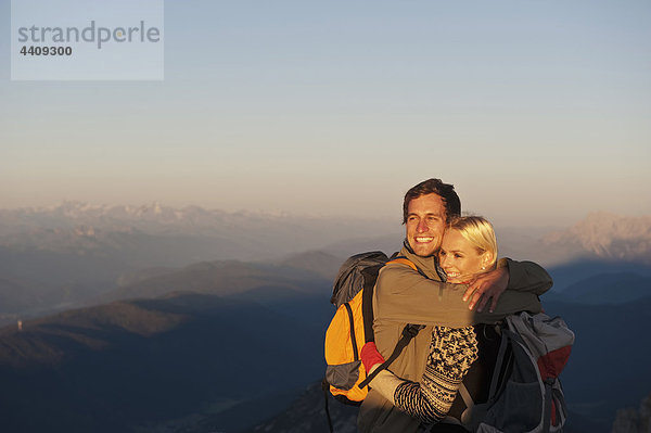 Österreich  Steiermark  Dachstein  Junges Paar umarmt den Berggipfel  lächelnd