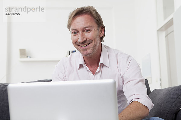 Mann mit Laptop  lächelnd