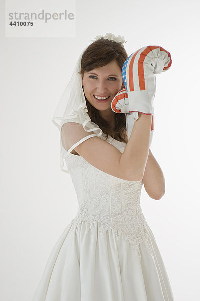 Porträt einer Braut mit Boxhandschuhen  lächelnd