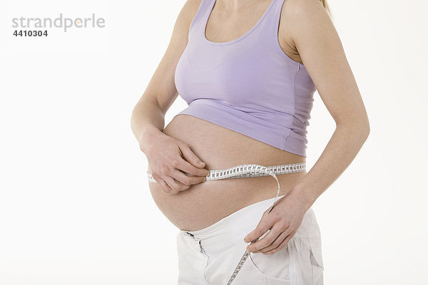 Schwangere Frau  die den Magen misst  Mittelteil