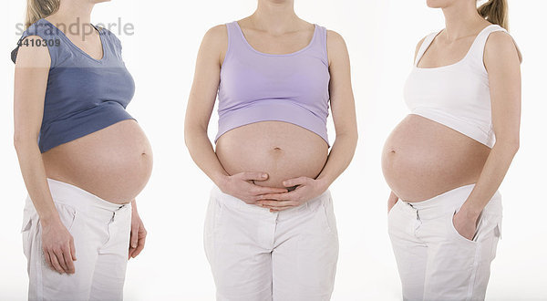 Drei schwangere Frauen stehend  Mittelteil