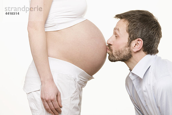 Mann  der den Bauch einer schwangeren Frau küsst  Seitenansicht