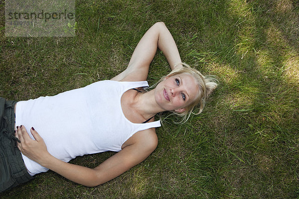 Junge Frau ruht auf Gras  lächelnd