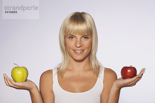 Junge Frau mit Äpfeln  lächelnd  Portrait