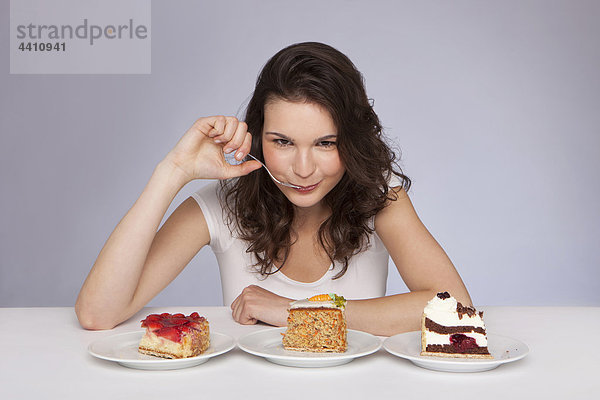 Junge Frau mit 3 Teller Kuchen  Portrait