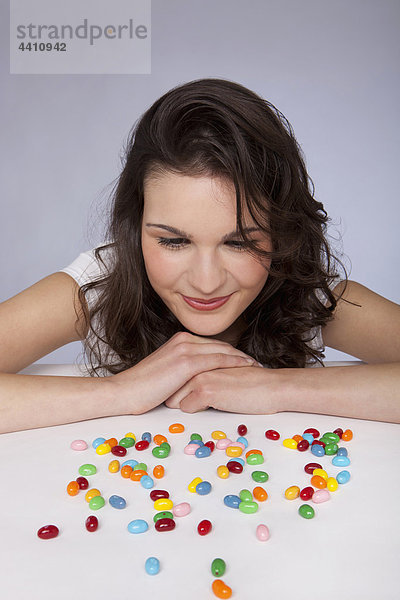 Junge Frau beim Anblick von Süßigkeiten  lächelnd