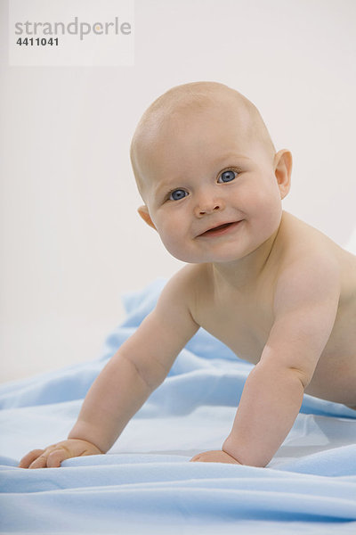 Baby Junge (6-11 Monate) krabbelnd  lächelnd  Portrait