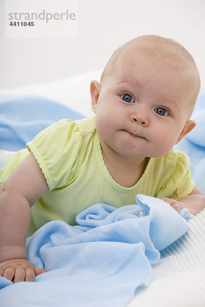Junge (6-11 Monate) liegend  lächelnd  Portrait