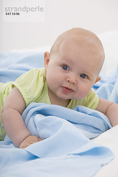 Junge (6-11 Monate) liegend  lächelnd  Portrait