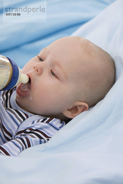 Babyboy (6-11 Monate) hält Babyflasche  Mund offen
