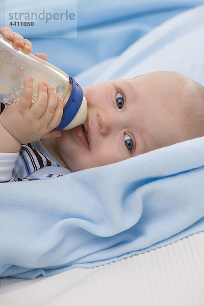 Baby Junge (6-11 Monate) trinkt Milch  lächelnd  Porträt