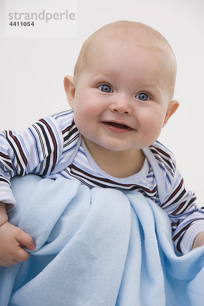 Baby Junge (6-11 Monate) lächelnd  wegschauend