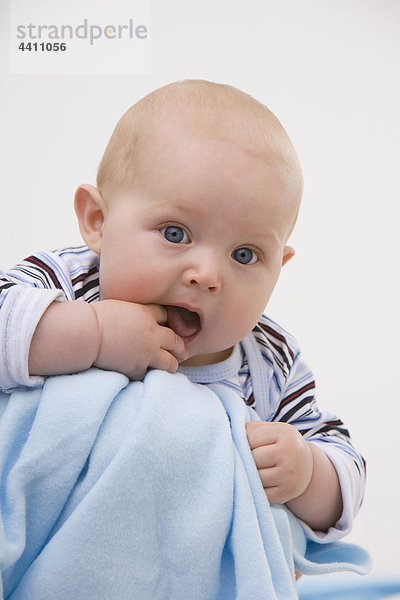Junge (6-11 Monate) mit Finger im Mund  Portrait