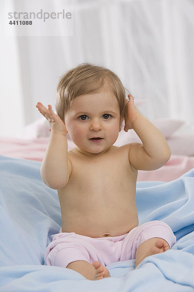 Baby Junge (6-11 Monate) übergibt Ohren  Porträt