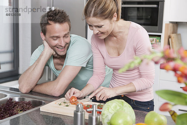 Deutschland  Paar Zubereitung Salat in der Küche  lächelnd