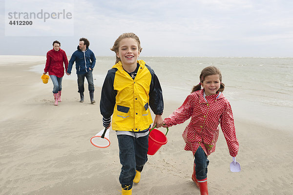 Deutschland  St. Peter-Ording  Nordsee  Kinder (6-9) mit Eltern  die am Strand spazieren gehen