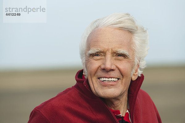 Nordsee  älterer Mann  der am Strand lächelt.