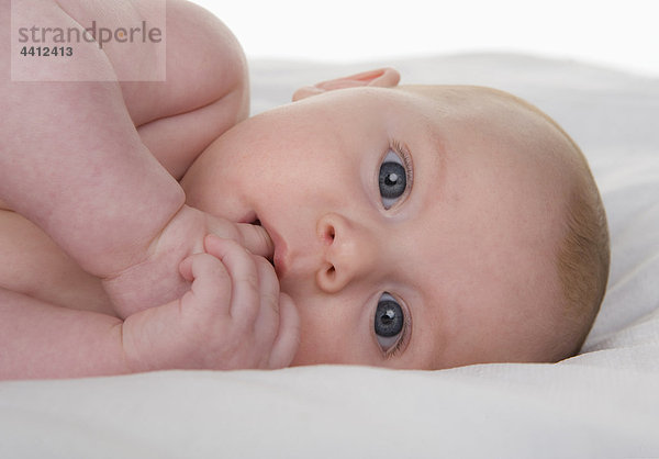 Baby Mädchen (2-5 Monate) Finger im Mund  Portrait