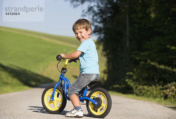 Österreich  Mondsee  Junge (2-3) Fahrrad fahren  lächelnd  Portrait