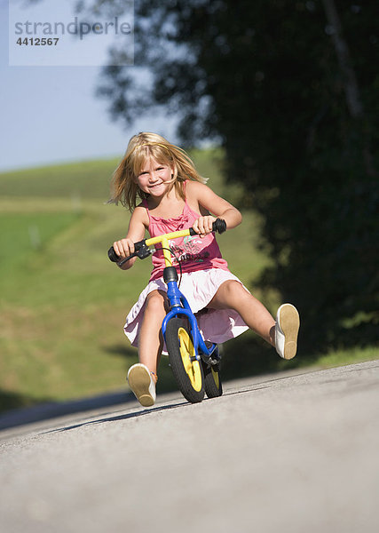Österreich  Mondsee  Mädchen (4-5) Fahrrad fahren  lächelnd  Portrait