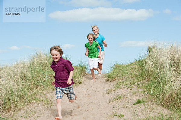 Brüder und Schwestern rennen zum Strand.