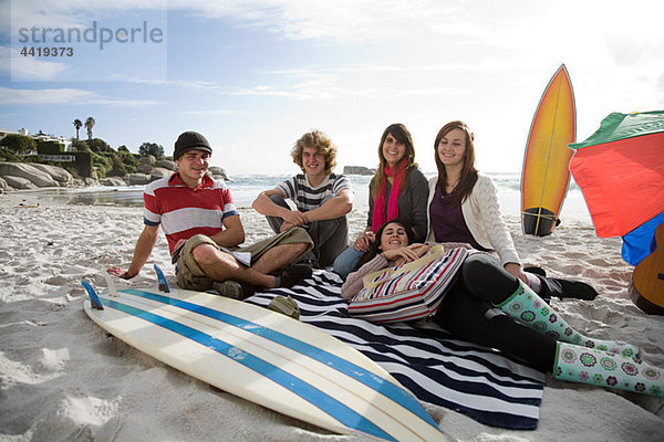 Freunde am Strand mit Surfbrett