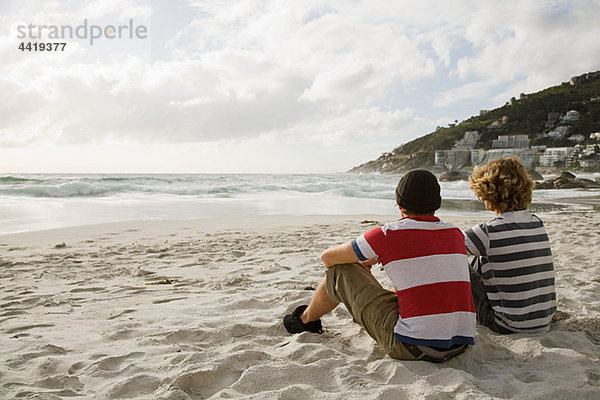Zwei Jungen sitzen am Strand