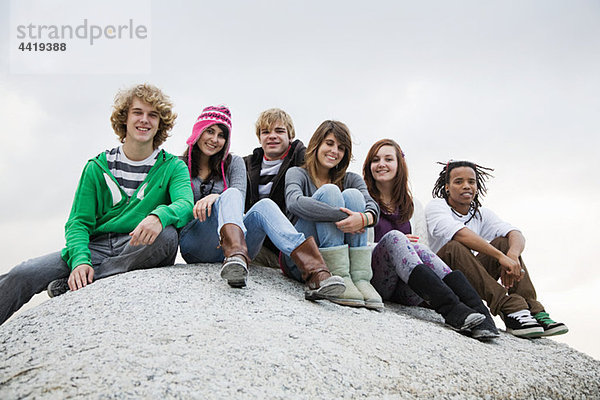 Gruppe von Freunden sitzen auf boulder