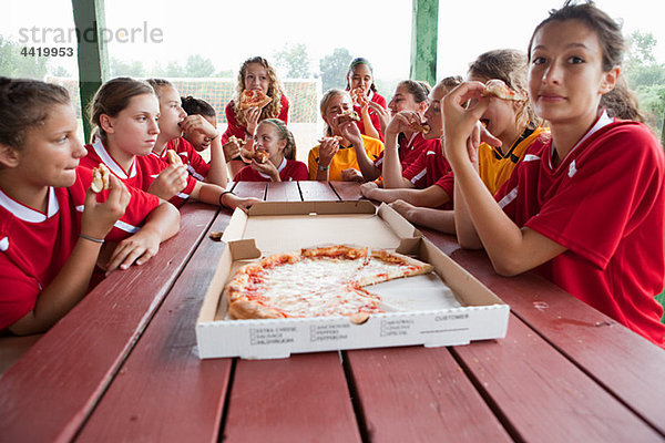 Weibliche Fußballmannschaft mit Pizza