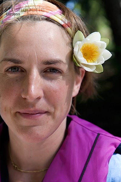 Frau trägt Blume im Haar  Lächeln  Nahaufnahme  portrait